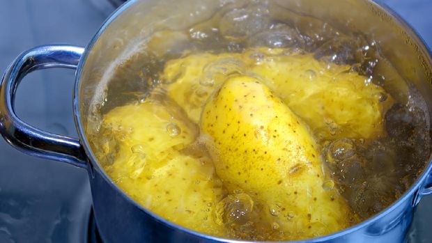 Kartoffeln werden in einem Kochtopf gekocht. Potatoes are cooked in a cooking pot.