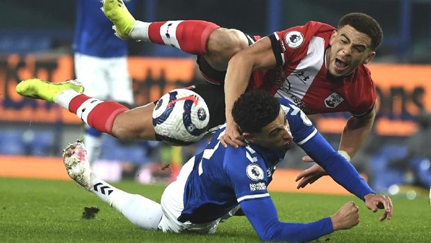 Southampton's Che Adams, top, and Everton's Ben Godfrey challenge for the ball during the English Premier League soccer match between Everton and Southampton at Goodison Park in Liverpool, England, Monday, March 1, 2021. (Gareth Copley/Pool via AP)