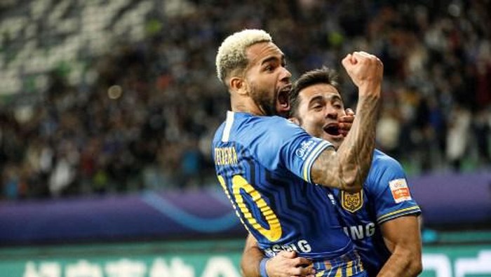 (FILES) This file photo taken on November 12, 2020 shows Jiangsu Sunings Alex Teixeira (L) who scored a goal celebrating after his team won the Chinese Super League (CSL) final football match between Guangzhou Evergrande and Jiangsu Suning in Suzhou in Chinas eastern Jiangsu province. - Chinese Super League champions Jiangsu FC have 