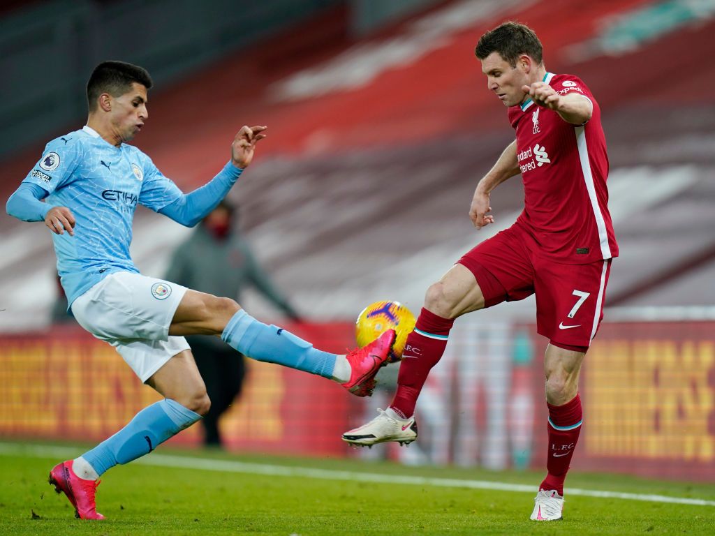 LIVERPOOL, ENGLAND - FEBRUARY 07: Joao Cancelo of Manchester City battles for possession with James Milner of Liverpool during the Premier League match between Liverpool and Manchester City at Anfield on February 07, 2021 in Liverpool, England. Sporting stadiums around the UK remain under strict restrictions due to the Coronavirus Pandemic as Government social distancing laws prohibit fans inside venues resulting in games being played behind closed doors (Photo by Tim Keeton - Pool/Getty Images)