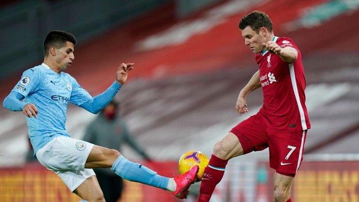 LIVERPOOL, ENGLAND - FEBRUARY 07: Joao Cancelo of Manchester City battles for possession with James Milner of Liverpool during the Premier League match between Liverpool and Manchester City at Anfield on February 07, 2021 in Liverpool, England. Sporting stadiums around the UK remain under strict restrictions due to the Coronavirus Pandemic as Government social distancing laws prohibit fans inside venues resulting in games being played behind closed doors (Photo by Tim Keeton - Pool/Getty Images)