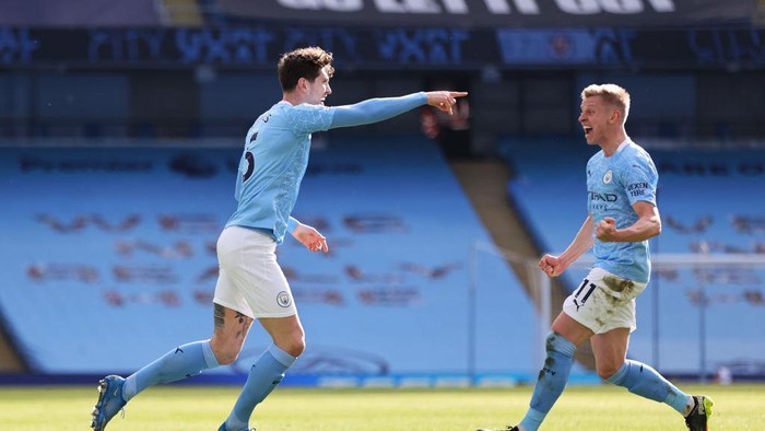 MANCHESTER, ENGLAND - FEBRUARY 27: John Stones of Manchester City celebrates with teammate Oleksandr Zinchenko after scoring his teams first goal during the Premier League match between Manchester City and West Ham United at Etihad Stadium on February 27, 2021 in Manchester, England. Sporting stadiums around the UK remain under strict restrictions due to the Coronavirus Pandemic as Government social distancing laws prohibit fans inside venues resulting in games being played behind closed doors. (Photo by Clive Brunskill/Getty Images)