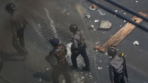 Riot policemen walk by the demonstrators-made makeshift barricades after riot police and soldiers cracked down anti-coup protesters in Mandalay, Myanmar, Wednesday, March 3, 2021. Demonstrators in Myanmar took to the streets again on Wednesday to protest last month's seizure of power by the military. (AP Photo)
