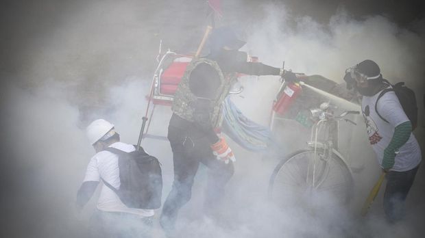 Tear gas and fire extinguisher gas float around demonstrators during a protest against the military coup in Yangon, Myanmar, March 3, 2021. REUTERS/Stringer
