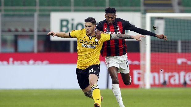 Udinese defender Kevin Bonifazi (14) dribbles the ball ahead of AC Milan forward Rafael Leao (17)during the Serie A soccer match between AC Milan and Udinese at the San Siro stadium, in Milan, Italy, Wednesday, March 3, 2021. (AP Photo/Antonio Calanni)