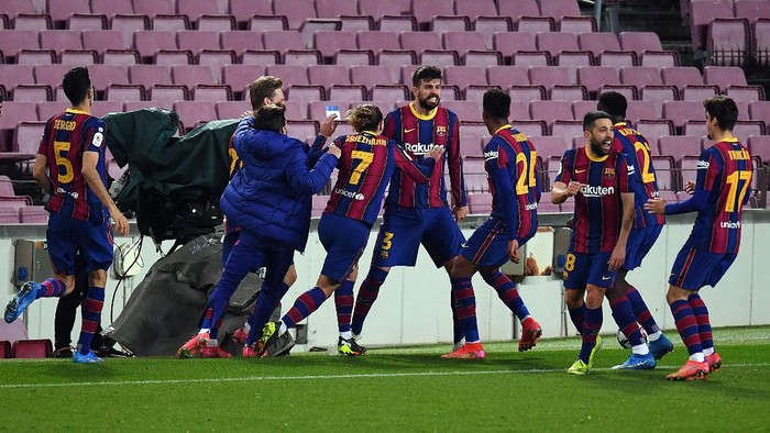 BARCELONA, SPAIN - MARCH 03: Gerard Pique of FC Barcelona  celebrates with teammates Antoine Griezmann and Juenior Firpo  after scoring their teams second goal  during the Copa del Rey Semi Final Second Leg match between FC Barcelona and Sevilla at Camp Nou on March 03, 2021 in Barcelona, Spain. Sporting stadiums around Spain remain under strict restrictions due to the Coronavirus Pandemic as Government social distancing laws prohibit fans inside venues resulting in games being played behind closed doors. (Photo by David Ramos/Getty Images)