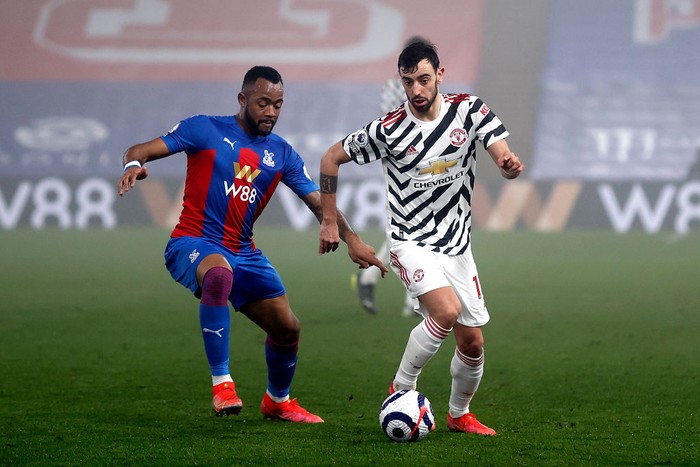 LONDON, ENGLAND - MARCH 03: Bruno Fernandes of Manchester United battles for possession with Jordan Ayew of Crystal Palace during the Premier League match between Crystal Palace and Manchester United at Selhurst Park on March 03, 2021 in London, England. Sporting stadiums around the UK remain under strict restrictions due to the Coronavirus Pandemic as Government social distancing laws prohibit fans inside venues resulting in games being played behind closed doors. (Photo by Adrian Dennis - Pool/Getty Images)