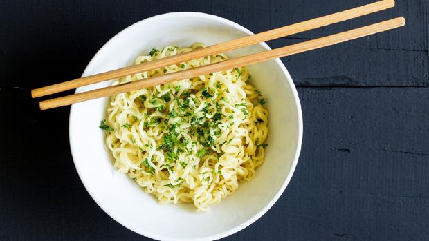 Instant noodles in bowl closeup top view with chop sticks on rustic black table