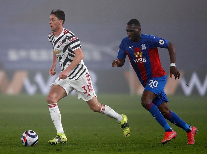 LONDON, ENGLAND - MARCH 03: Nemanja Matic of Manchester United runs with the ball whilst under pressure from Christian Benteke of Crystal Palace during the Premier League match between Crystal Palace and Manchester United at Selhurst Park on March 03, 2021 in London, England. Sporting stadiums around the UK remain under strict restrictions due to the Coronavirus Pandemic as Government social distancing laws prohibit fans inside venues resulting in games being played behind closed doors. (Photo by Adrian Dennis - Pool/Getty Images)