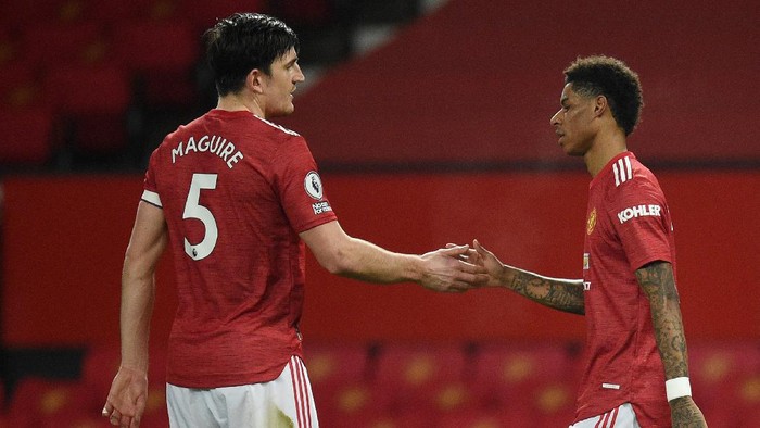 MANCHESTER, ENGLAND - FEBRUARY 21: Marcus Rashford of Manchester United celebrates with Harry Maguire after scoring his teams first goal during the Premier League match between Manchester United and Newcastle United at Old Trafford on February 21, 2021 in Manchester, England. Sporting stadiums around the UK remain under strict restrictions due to the Coronavirus Pandemic as Government social distancing laws prohibit fans inside venues resulting in games being played behind closed doors. (Photo by Oli Scarff - Pool/Getty Images)