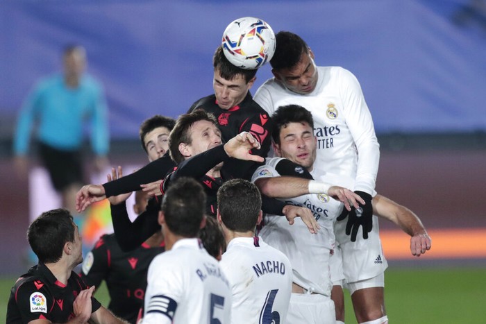 Real Madrid and Real Sociedad players jump for the header during the Spanish La Liga soccer match between Real Madrid and Real Sociedad at Alfredo di Stefano stadium in Madrid, Spain, Monday, March 1, 2021. (AP Photo/Bernat Armangue)
