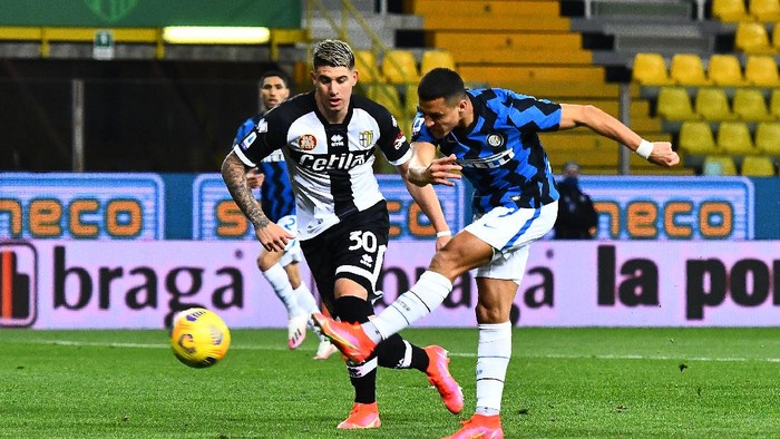 PARMA, ITALY - MARCH 04: Alexis Sanchez of Internazionale scores his sides first goal whilst under pressure from Lautaro Valenti of Parma Calcio 1913 during the Serie A match between Parma Calcio and FC Internazionale at Stadio Ennio Tardini on March 04, 2021 in Parma, Italy. Sporting stadiums around Italy remain under strict restrictions due to the Coronavirus Pandemic as Government social distancing laws prohibit fans inside venues resulting in games being played behind closed doors. (Photo by Alessandro Sabattini/Getty Images)