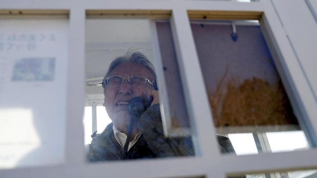 Korban Tsunami Jepang Mengenang Orang Tercinta di Kotak Telepon Angin Kazuyoshi Sasaki, 67, who lost his wife, Miwako, in the March 11, 2011 earthquake and tsunami, reacts as he calls his late wife inside Kazo-no-Denwa (the phone of the wind), a phone booth set up for people to call their deceased loved ones, ahead of the 10th anniversary of the disaster, at Bell Gardia Kujira-yama in Otsuchi town, Iwate Prefecture, northern Japan, February 27, 2021. Inside, Sasaki dials his wife's cellphone number. He explains how he searched for her for days.