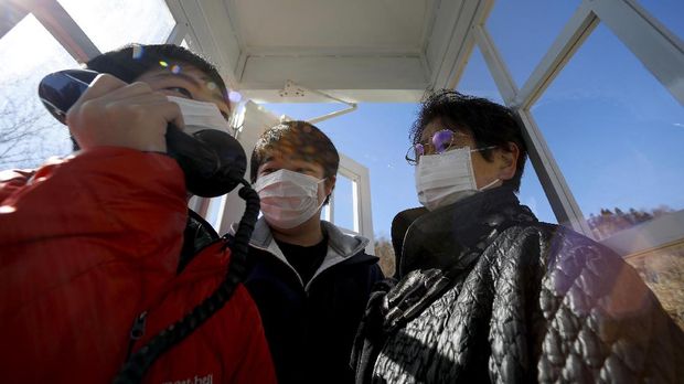 Korban Tsunami Jepang Mengenang Orang Tercinta di Kotak Telepon Angin Sachiko Okawa, 76, who lost her husband in the March 11, 2011 earthquake and tsunami, calls her late husband with her two grandsons Reo and Daina inside Kaze-no-Denwa (the phone of the wind), a phone booth set up for people to call their deceased loved ones, at Bell Gardia Kujira-yama, ahead of the 10th anniversary of the disaster, in Otsuchi town, Iwate Prefecture, northern Japan, February 27, 2021.