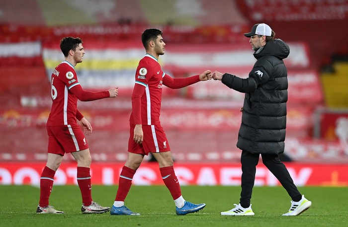 LIVERPOOL, ENGLAND - MARCH 04: Jurgen Klopp, Manager of Liverpool interacts with Ozan Kabak and Andy Robertson (L) of Liverpool following the Premier League match between Liverpool and Chelsea at Anfield on March 04, 2021 in Liverpool, England. Sporting stadiums around the UK remain under strict restrictions due to the Coronavirus Pandemic as Government social distancing laws prohibit fans inside venues resulting in games being played behind closed doors. (Photo by Laurence Griffiths/Getty Images)