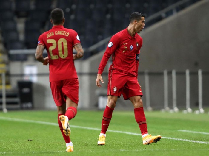STOCKHOLM, SWEDEN - SEPTEMBER 08: Cristiano Ronaldo of Portugal celebrates with teammate Joao Cancelo after scoring his team's first goal during the UEFA Nations League group stage match between Sweden and Portugal at Friends Arena on September 08, 2020 in Stockholm, Sweden. (Photo by Linnea Rheborg/Getty Images)
