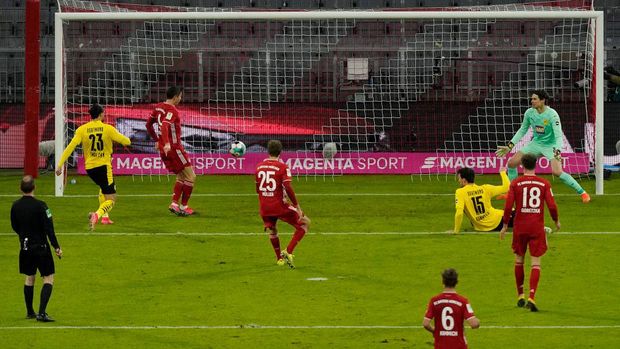 MUNICH, GERMANY - MARCH 06: Robert Lewandowski of FC Bayern Muenchen  scores their team's first goal  during the Bundesliga match between FC Bayern Muenchen and Borussia Dortmund at Allianz Arena on March 06, 2021 in Munich, Germany. Sporting stadiums around Germany remain under strict restrictions due to the Coronavirus Pandemic as Government social distancing laws prohibit fans inside venues resulting in games being played behind closed doors. (Photo by Günter Schiffmann - Pool/Getty Images)