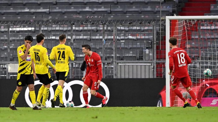 MUNICH, GERMANY - MARCH 06: Robert Lewandowski of FC Bayern Muenchen  celebrates after scoring their teams second goal during the Bundesliga match between FC Bayern Muenchen and Borussia Dortmund at Allianz Arena on March 06, 2021 in Munich, Germany. Sporting stadiums around Germany remain under strict restrictions due to the Coronavirus Pandemic as Government social distancing laws prohibit fans inside venues resulting in games being played behind closed doors. (Photo by Sebastian Widmann/Getty Images)