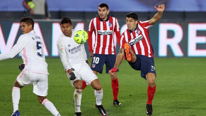 MADRID, SPAIN - DECEMBER 12: Luis Suarez of Atletico de Madrid shoots under pressure from Casemiro of Real Madrid during the La Liga Santander match between Real Madrid and Atletico de Madrid at Estadio Alfedo Di Stefano on December 12, 2020 in Madrid, Spain. Sporting stadiums around Spain remain under strict restrictions due to the Coronavirus Pandemic as Government social distancing laws prohibit fans inside venues resulting in games being played behind closed doors. (Photo by Angel Martinez/Getty Images)