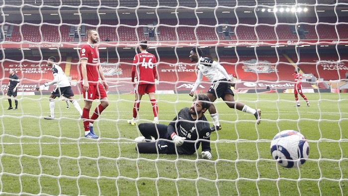 Liverpools goalkeeper Alisson fails to save the goal from Fulhams Mario Lemina during the English Premier League soccer match between Liverpool and Fulham at Anfield stadium in Liverpool, England, Sunday, March 7, 2021. (Phil Noble/Pool via AP)