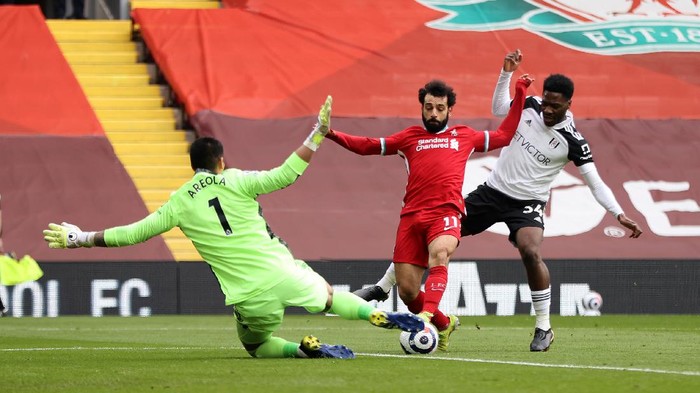 LIVERPOOL, ENGLAND - MARCH 07: Mohamed Salah of Liverpool is challenged by Alphonse Areola and Ola Aina of Fulham during the Premier League match between Liverpool and Fulham at Anfield on March 07, 2021 in Liverpool, England. Sporting stadiums around the UK remain under strict restrictions due to the Coronavirus Pandemic as Government social distancing laws prohibit fans inside venues resulting in games being played behind closed doors. (Photo by Clive Brunskill/Getty Images)