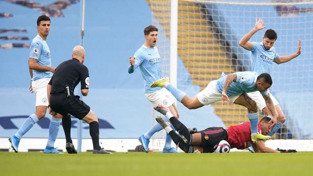 MANCHESTER, ENGLAND - MARCH 07: Anthony Martial of Manchester United is fouled by Gabriel Jesus and Ruben Dias of Manchester City in the box leading to a penalty being given during the Premier League match between Manchester City and Manchester United at Etihad Stadium on March 07, 2021 in Manchester, England. Sporting stadiums around the UK remain under strict restrictions due to the Coronavirus Pandemic as Government social distancing laws prohibit fans inside venues resulting in games being played behind closed doors. (Photo by Dave Thompson - Pool/Getty Images)