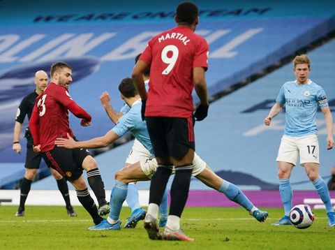 MANCHESTER, ENGLAND - MARCH 07: Luke Shaw of Manchester United scores their sides second goal during the Premier League match between Manchester City and Manchester United at Etihad Stadium on March 07, 2021 in Manchester, England. Sporting stadiums around the UK remain under strict restrictions due to the Coronavirus Pandemic as Government social distancing laws prohibit fans inside venues resulting in games being played behind closed doors. (Photo by Dave Thompson - Pool/Getty Images)