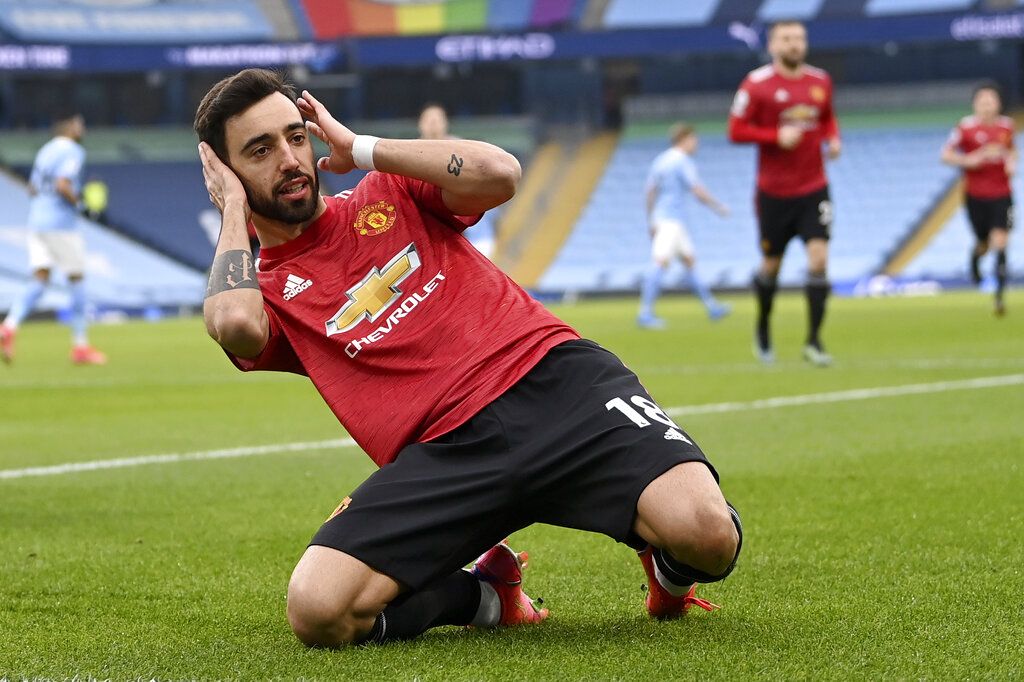 Manchester United's Bruno Fernandes celebrates after scoring the opening goal during the English Premier League soccer match between Manchester City and Manchester United at the Etihad Stadium in Manchester, England, Sunday, March 7, 2021. (Laurence Griffiths/Pool via AP)