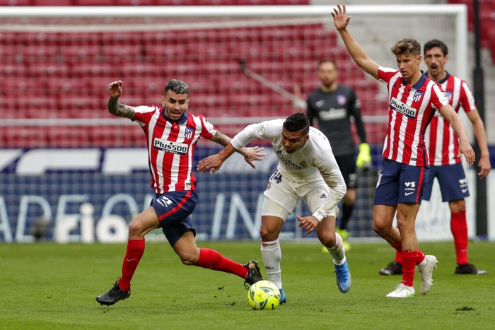 Atletico Madrids Angel Correa, left, and Real Madrids Casemiro vie for the ball during the Spanish La Liga soccer match between Atletico Madrid and Real Madrid at the Wanda Metropolitano stadium in Madrid, Spain, Sunday, March 7, 2021. (AP Photo/Manu Fernandez)