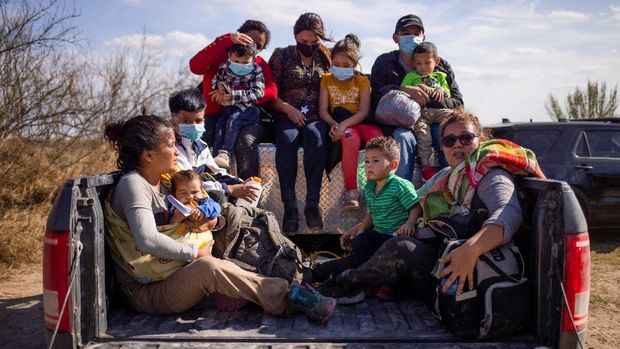 Migrant families and children sit in the back of a police truck for transport after they crossed the Rio Grande River into the United States from Mexico in Penitas, Texas, U.S., March 5, 2021. REUTERS/Adrees Latif     TPX IMAGES OF THE DAY