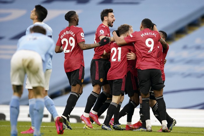 Manchester United players celebrate after scoring their second goal during the English Premier League soccer match between Manchester City and Manchester United at the Etihad Stadium in Manchester, England, Sunday, March 7, 2021. (Dave Thompson/Pool via AP)