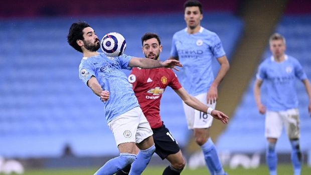 Manchester City's Ilkay Gundogan, left, controls the ball next to Manchester United's Bruno Fernandes during the English Premier League soccer match between Manchester City and Manchester United at the Etihad Stadium in Manchester, England, Sunday, March 7, 2021. (Laurence Griffiths/Pool via AP)