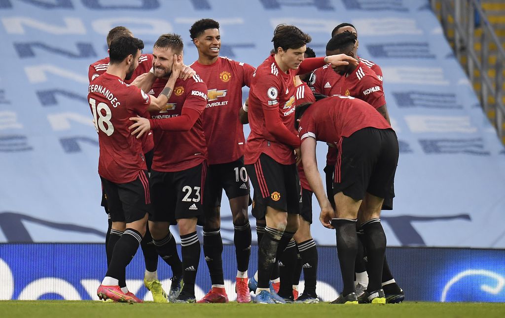 MANCHESTER, ENGLAND - MARCH 07: Luke Shaw of Manchester United celebrates with Bruno Fernandes, Marcus Rashford and team mates after scoring their side's second goal during the Premier League match between Manchester City and Manchester United at Etihad Stadium on March 07, 2021 in Manchester, England. Sporting stadiums around the UK remain under strict restrictions due to the Coronavirus Pandemic as Government social distancing laws prohibit fans inside venues resulting in games being played behind closed doors. (Photo by Peter Powell - Pool/Getty Images)