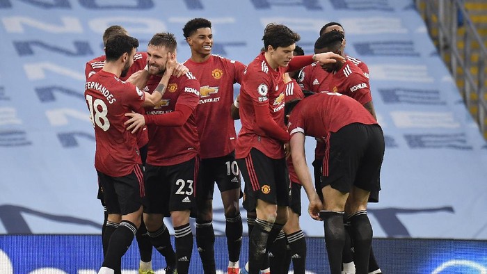 MANCHESTER, ENGLAND - MARCH 07: Luke Shaw of Manchester United celebrates with Bruno Fernandes, Marcus Rashford and team mates after scoring their sides second goal during the Premier League match between Manchester City and Manchester United at Etihad Stadium on March 07, 2021 in Manchester, England. Sporting stadiums around the UK remain under strict restrictions due to the Coronavirus Pandemic as Government social distancing laws prohibit fans inside venues resulting in games being played behind closed doors. (Photo by Peter Powell - Pool/Getty Images)
