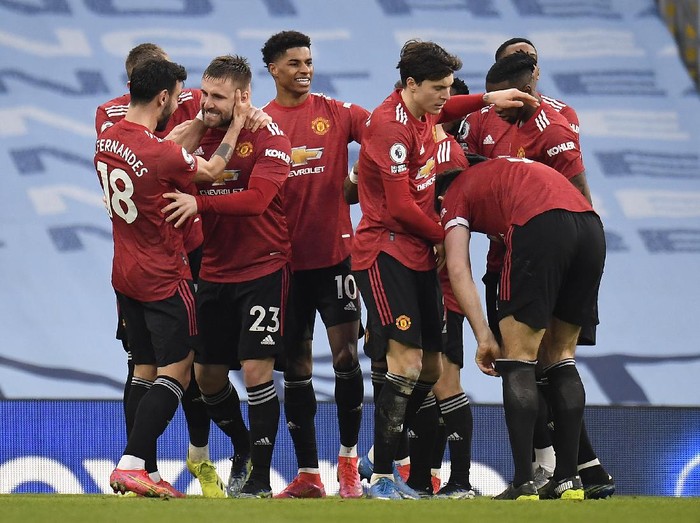 MANCHESTER, ENGLAND - MARCH 07: Luke Shaw of Manchester United celebrates with Bruno Fernandes, Marcus Rashford and team mates after scoring their sides second goal during the Premier League match between Manchester City and Manchester United at Etihad Stadium on March 07, 2021 in Manchester, England. Sporting stadiums around the UK remain under strict restrictions due to the Coronavirus Pandemic as Government social distancing laws prohibit fans inside venues resulting in games being played behind closed doors. (Photo by Peter Powell - Pool/Getty Images)
