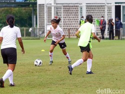 Seorang pemain tengah mendribel bola.