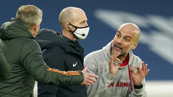 Manchester Citys head coach Pep Guardiola, right, gestures to Manchester Uniteds manager Ole Gunnar Solskjaer, left, during the English Premier League soccer match between Manchester City and Manchester United at the Etihad Stadium in Manchester, England, Sunday, March 7, 2021. (Dave Thompson/Pool via AP)