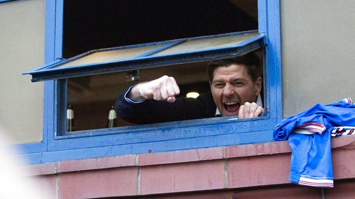 Rangers manager Steven Gerrard hangs out the window of the dressing room to cheer with fans gathered outside the stadium after their win in the Scottish Premiership match against St Mirren, at Ibrox Stadium in Glasgow, Scotland, Saturday March 6, 2021. Some thousands of fans gathered outside the stadium celebrating the win against St. Mirren, putting them on the brink of securing the Scottish Premiership title. (Jane Barlow/PA via AP)