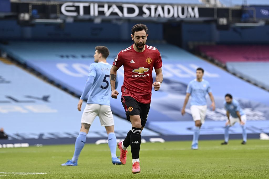 Manchester United's Bruno Fernandes celebrates after scoring the opening goal during the English Premier League soccer match between Manchester City and Manchester United at the Etihad Stadium in Manchester, England, Sunday, March 7, 2021. (Laurence Griffiths/Pool via AP)