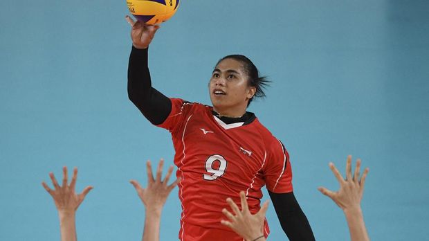 Indonesia's Aprilia Santini Manganang hits the ball during their women's Group A preliminary volleyball match between the Indonesia and Japan at the 2018 Asian Games in Jakarta on August 19, 2018. (Photo by ANTHONY WALLACE / AFP)