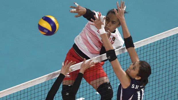 Indonesia's Aprilia Santini Manganang (L) hits the ball during their women's group A preliminary volleyball match between Hong Kong and Indonesia at the 2018 Asian Games in Jakarta on August 21, 2018. (Photo by Arief Bagus / AFP)