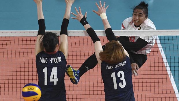 Indonesia's Aprilia Santini Manganang (R) spikes the ball past South Korea's Yang Hyojin (L) and Park Jeon-gah during the women's quarter-final volleyball match between Indonesia and South Korea at the 2018 Asian Games in Jakarta on August 29, 2018. (Photo by MONEY SHARMA / AFP)