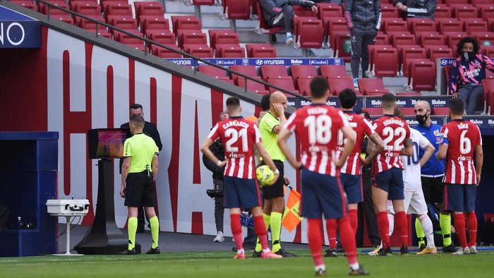 MADRID, SPAIN - MARCH 07: Referee, Alejandro Jose Hernandez Hernandezas checks the VAR monitor for a potential handball on Nacho of Real Madrid during the La Liga Santander match between Atletico de Madrid and Real Madrid at Estadio Wanda Metropolitano on March 07, 2021 in Madrid, Spain. Sporting stadiums around Spain remain under strict restrictions due to the Coronavirus Pandemic as Government social distancing laws prohibit fans inside venues resulting in games being played behind closed doors. (Photo by Denis Doyle/Getty Images)