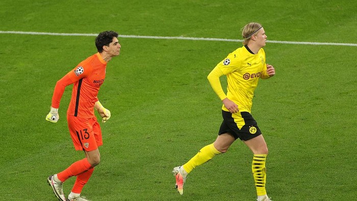 DORTMUND, GERMANY - MARCH 09: Yassine Bounou of Sevilla interacts with Erling Haaland of Borussia Dortmund during the UEFA Champions League Round of 16 match between Borussia Dortmund and Sevilla FC at Signal Iduna Park on March 09, 2021 in Dortmund, Germany. Sporting stadiums around Germany remain under strict restrictions due to the Coronavirus Pandemic as Government social distancing laws prohibit fans inside venues resulting in games being played behind closed doors. (Photo by Friedemann Vogel - Pool/Getty Images)