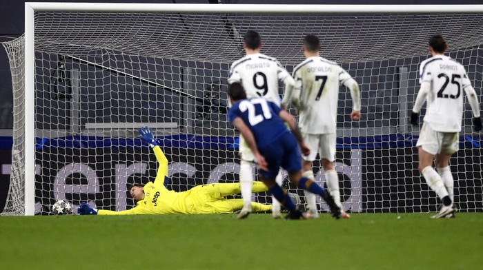 Juventus goalkeeper Wojciech Szczesny, left, cant stop a goal by Portos Portos Sergio Oliveira (27) during the Champions League, round of 16, second leg, soccer match between Juventus and Porto in Turin, Italy, Tuesday, March 9, 2021. (Fabio Ferrari/LaPresse via AP)