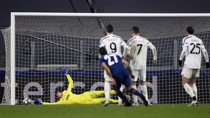 Juventus goalkeeper Wojciech Szczesny, left, cant stop a goal by Portos Portos Sergio Oliveira (27) during the Champions League, round of 16, second leg, soccer match between Juventus and Porto in Turin, Italy, Tuesday, March 9, 2021. (Fabio Ferrari/LaPresse via AP)
