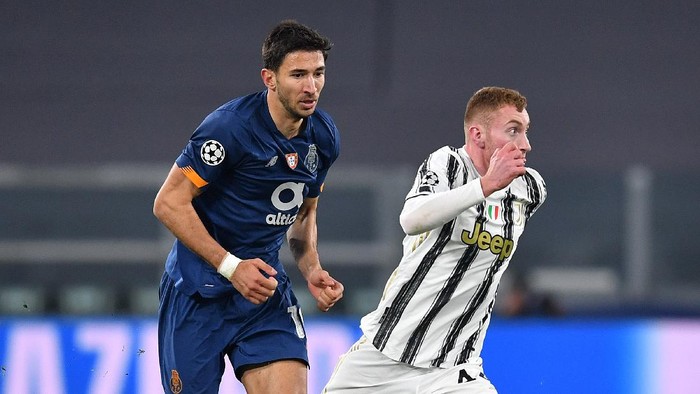 TURIN, ITALY - MARCH 09: Dejan Kulusevski of Juventus runs with the ball whilst under pressure from Marko Grujic of Porto during the UEFA Champions League Round of 16 match between Juventus and FC Porto at Juventus Arena on March 09, 2021 in Turin, Italy. Sporting stadiums around Italy remain under strict restrictions due to the Coronavirus Pandemic as Government social distancing laws prohibit fans inside venues resulting in games being played behind closed doors. (Photo by Valerio Pennicino/Getty Images)