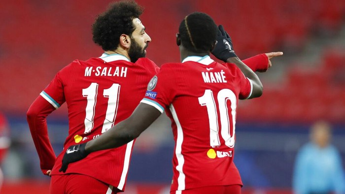 Liverpools Mohamed Salah, left, celebrates after scoring his sides opening goal during the Champions League round of 16 second leg soccer match between Liverpool and RB Leipzig at the Puskas Arena stadium in Budapest, Hungary, Wednesday, March 10, 2021. (AP Photo/Laszlo Balogh)