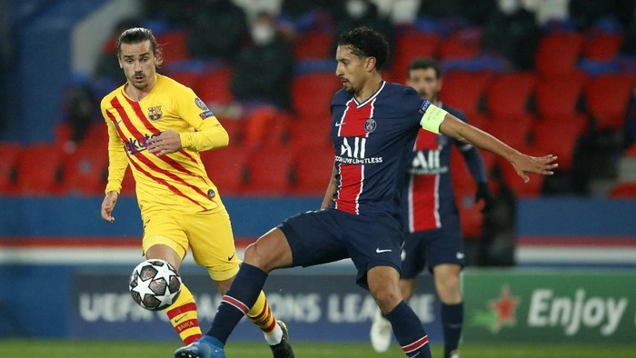 PSGs Marquinhos, right, clears the ball past Barcelonas Antoine Griezmann during the Champions League, round of 16, second leg soccer match between Paris Saint-Germain and FC Barcelona at the Parc des Princes stadium in Paris, Wednesday, March 10, 2021. (AP Photo/Christophe Ena)