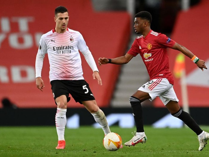 MANCHESTER, ENGLAND - MARCH 11: Amad Diallo of Manchester United runs with the ball under pressure from Diogo Dalot of A.C. Milan during the UEFA Europa League Round of 16 First Leg match between Manchester United and A.C. Milan at Old Trafford on March 11, 2021 in Manchester, England. Sporting stadiums around the UK remain under strict restrictions due to the Coronavirus Pandemic as Government social distancing laws prohibit fans inside venues resulting in games being played behind closed doors. (Photo by Laurence Griffiths/Getty Images)